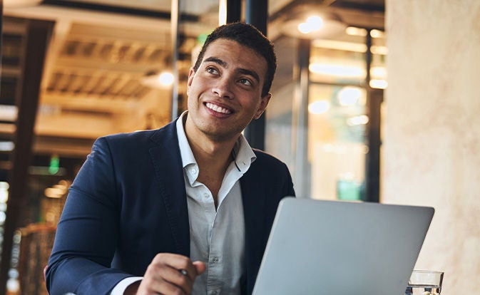 Man smiling while using laptop