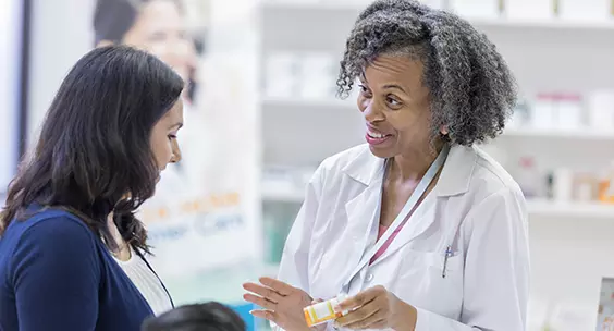Pharmacist delivering medicine to a woman