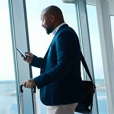 A man engaged with his smartphone at the airport terminal.