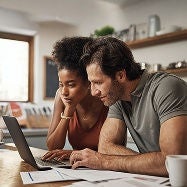 A man and woman looking at a laptop