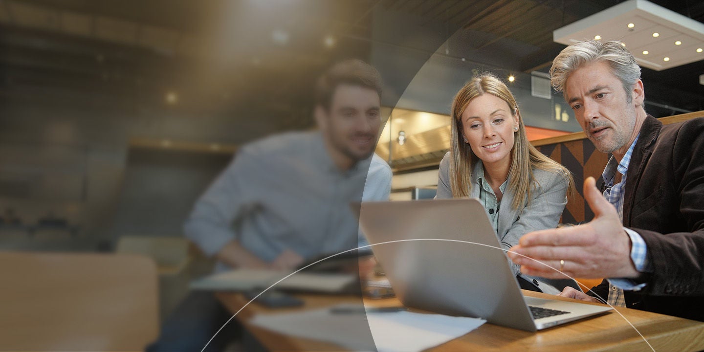 3 team members looking at laptop screen.