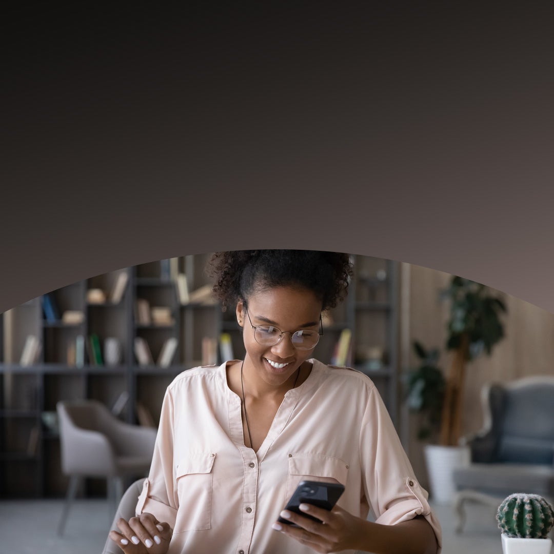 A woman in pink coat using smartphone.
