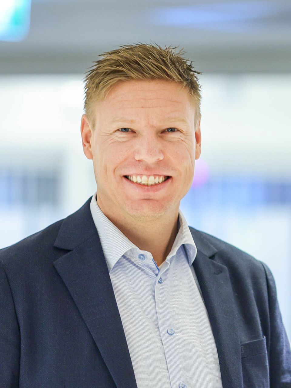 Portrett av Tony Rogne stående mot en enkel bakgrunn.