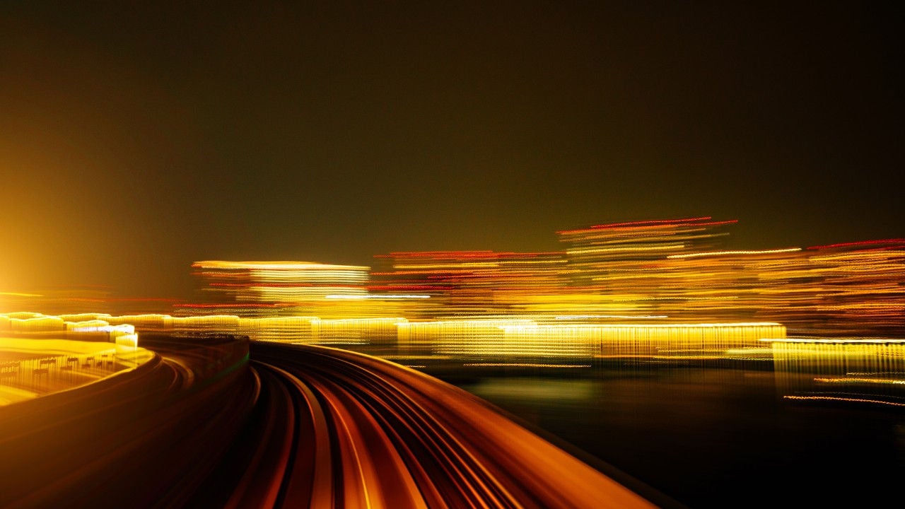 Light trails in orange, red and yellow against a dark background.