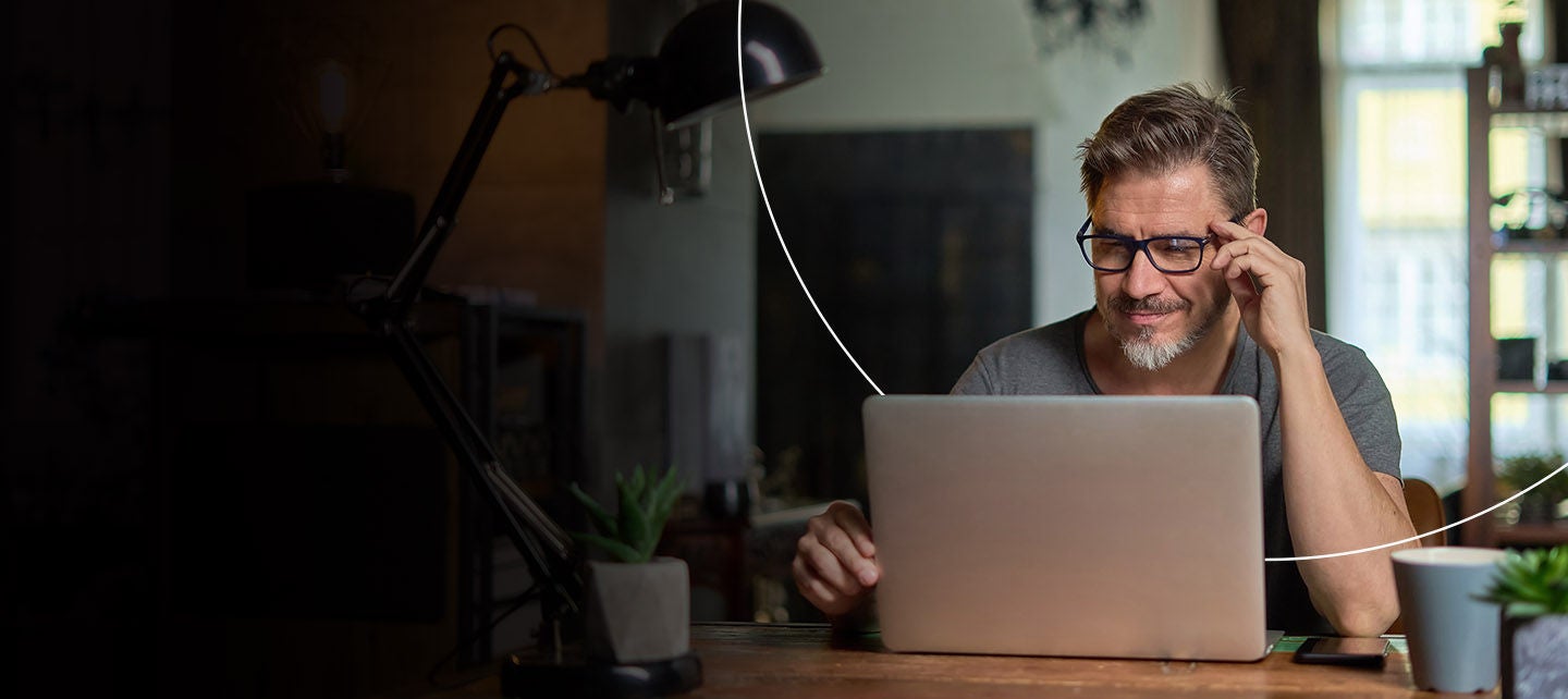 Muškarac koristi svoj laptop pored prozora