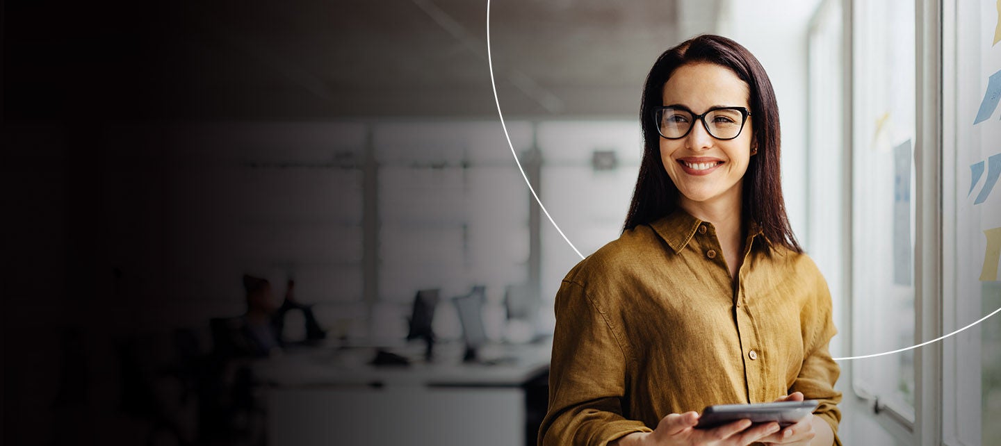 Žena drži telefon, smiješeći se