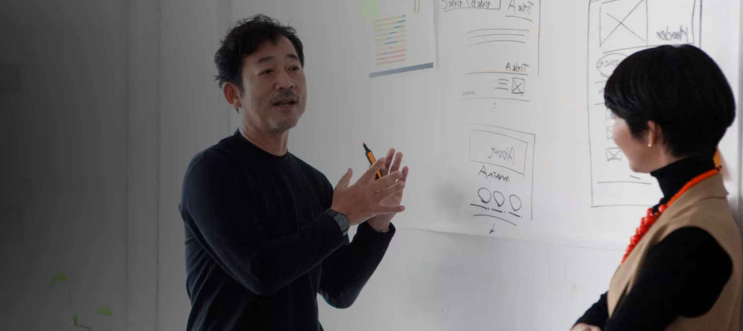 Man and woman collaborating in front of whiteboard