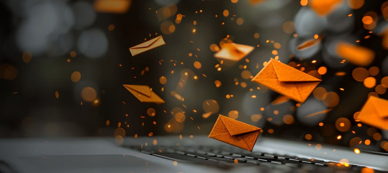 orange envelopes flying above laptop