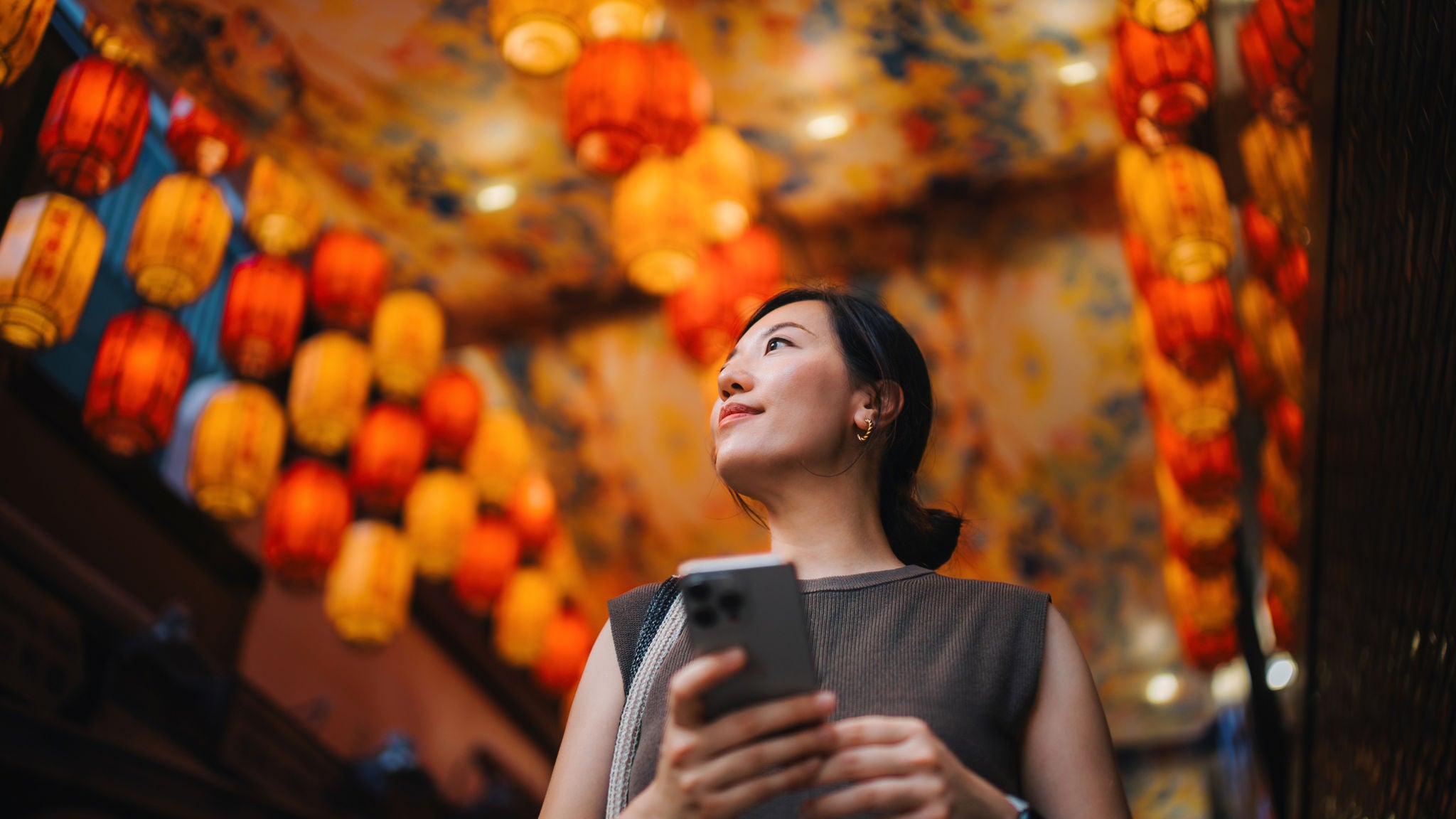 Mujer en un mercado bien iluminado sosteniendo un teléfono