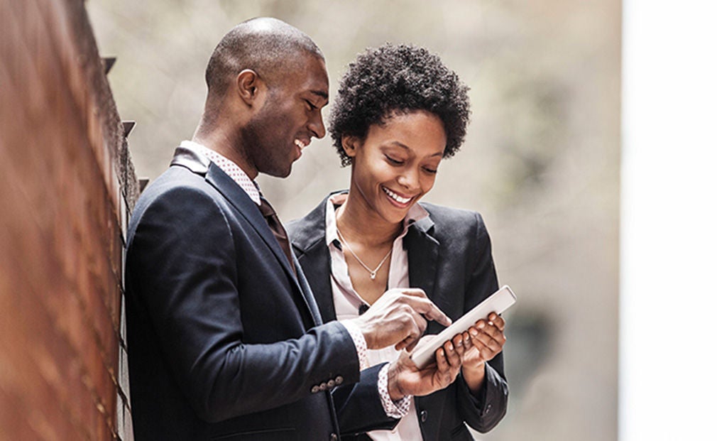 A man and a woman smiling at a phone