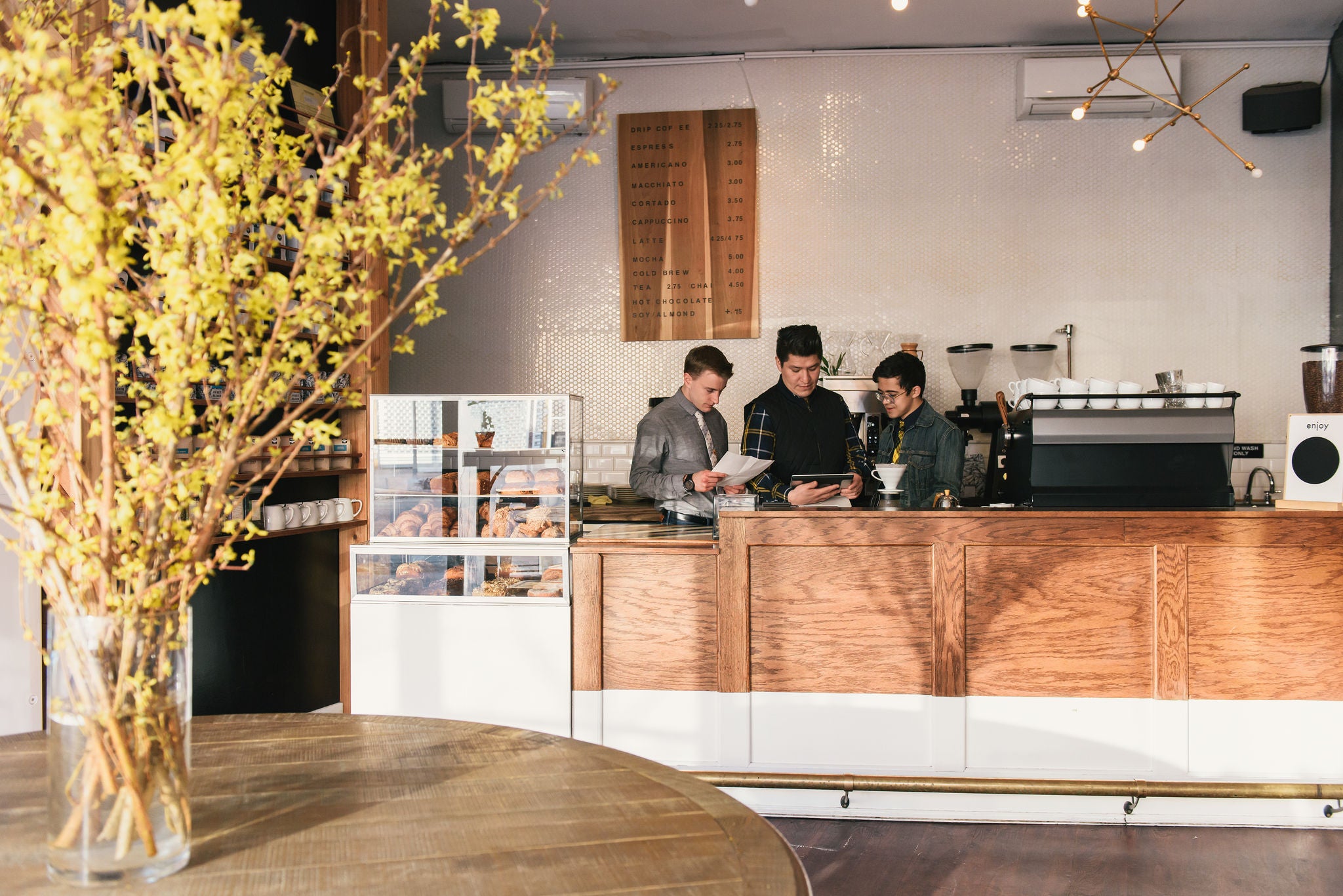 Manager and waiters checking paperwork at coffee shop counter