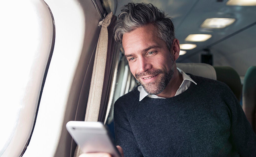 Man on plane using a phone