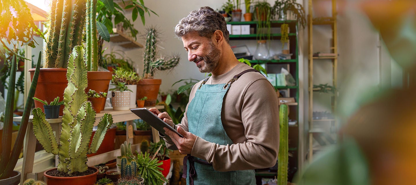 Man in his plant shop reviewing stock
