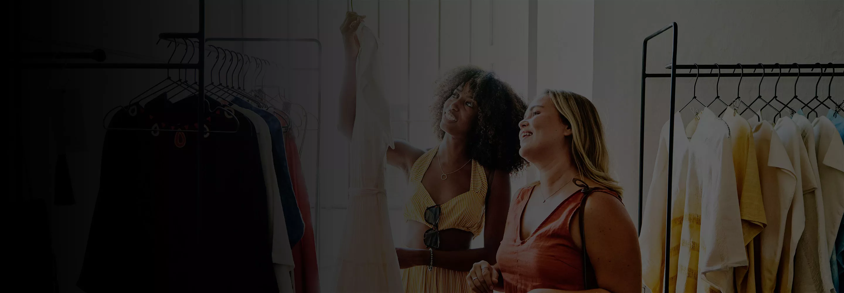 Women selecting clothes from stand