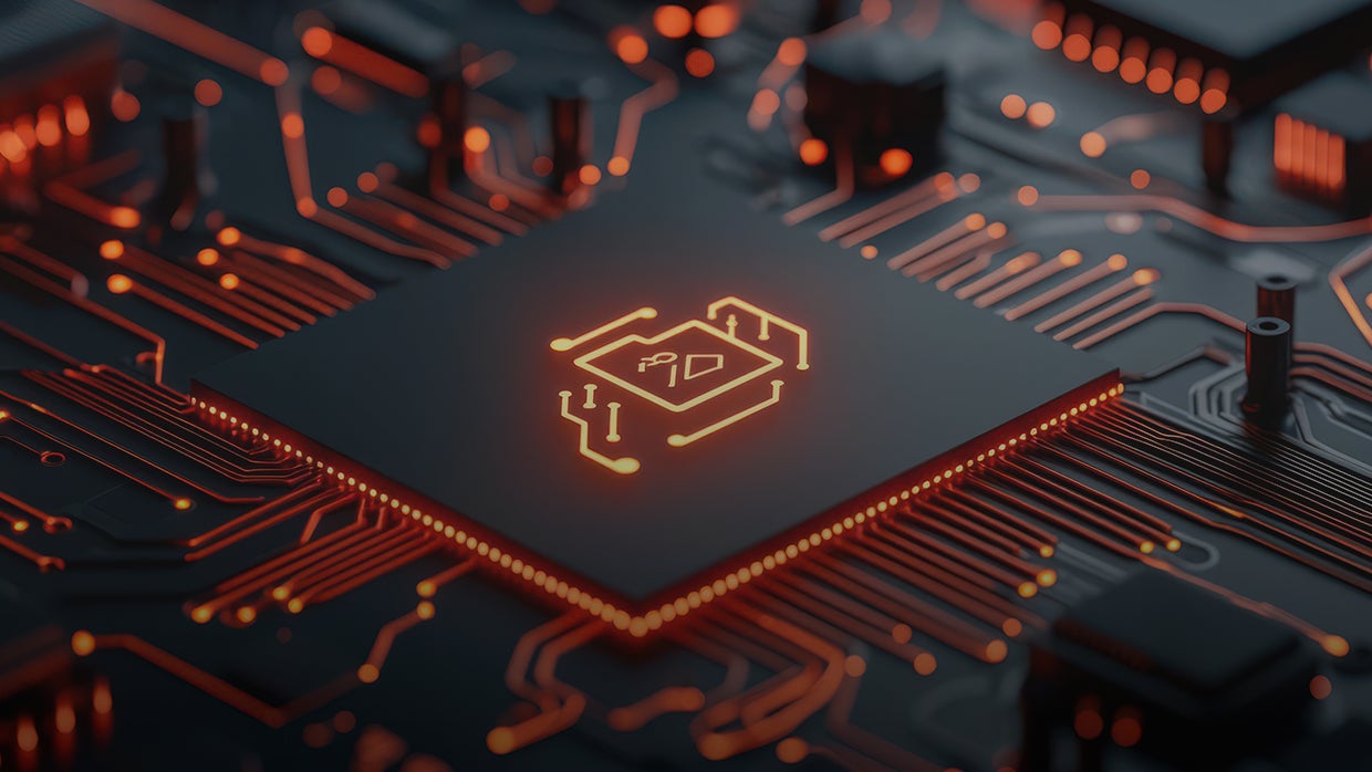 Nærbillede af en glødende printplade med en oplyst chip. 