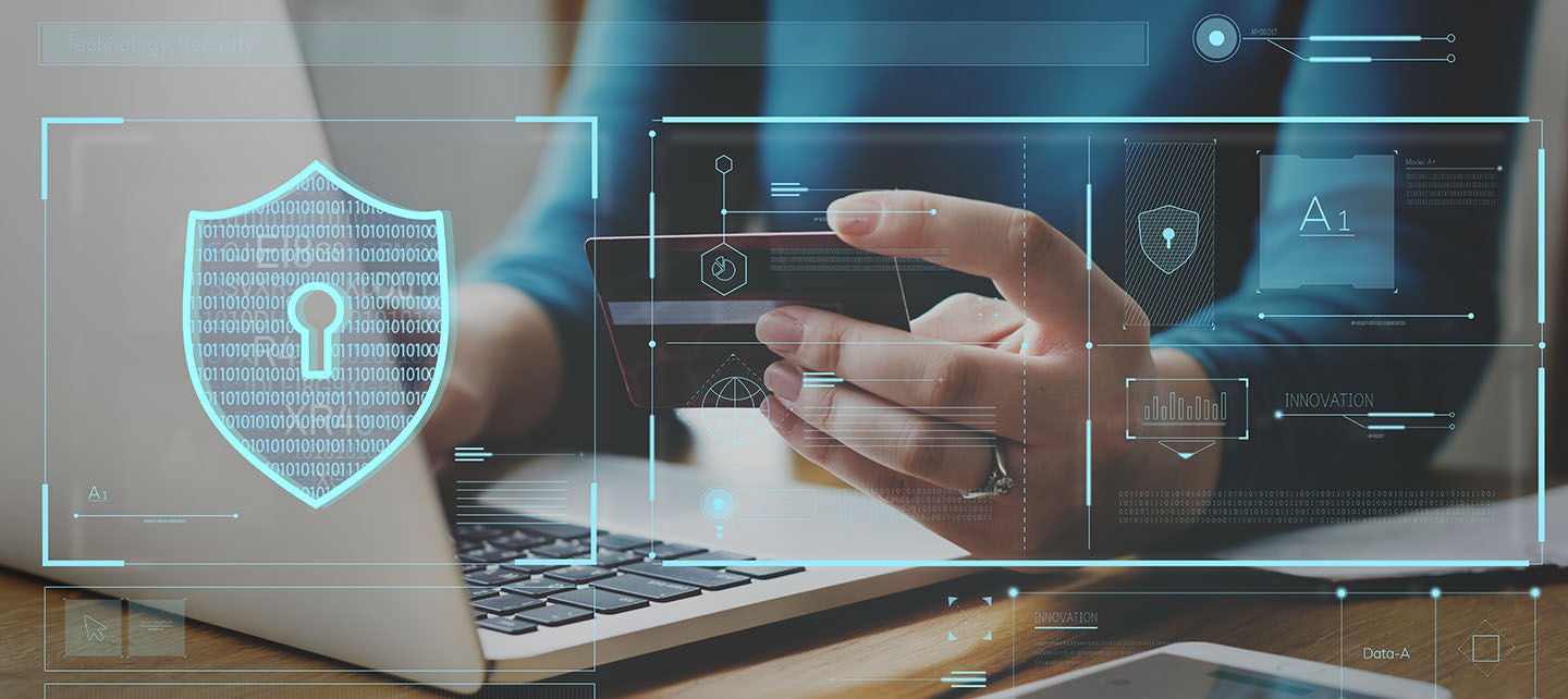 Woman using credit card while on a laptop with digital security graphics overlay