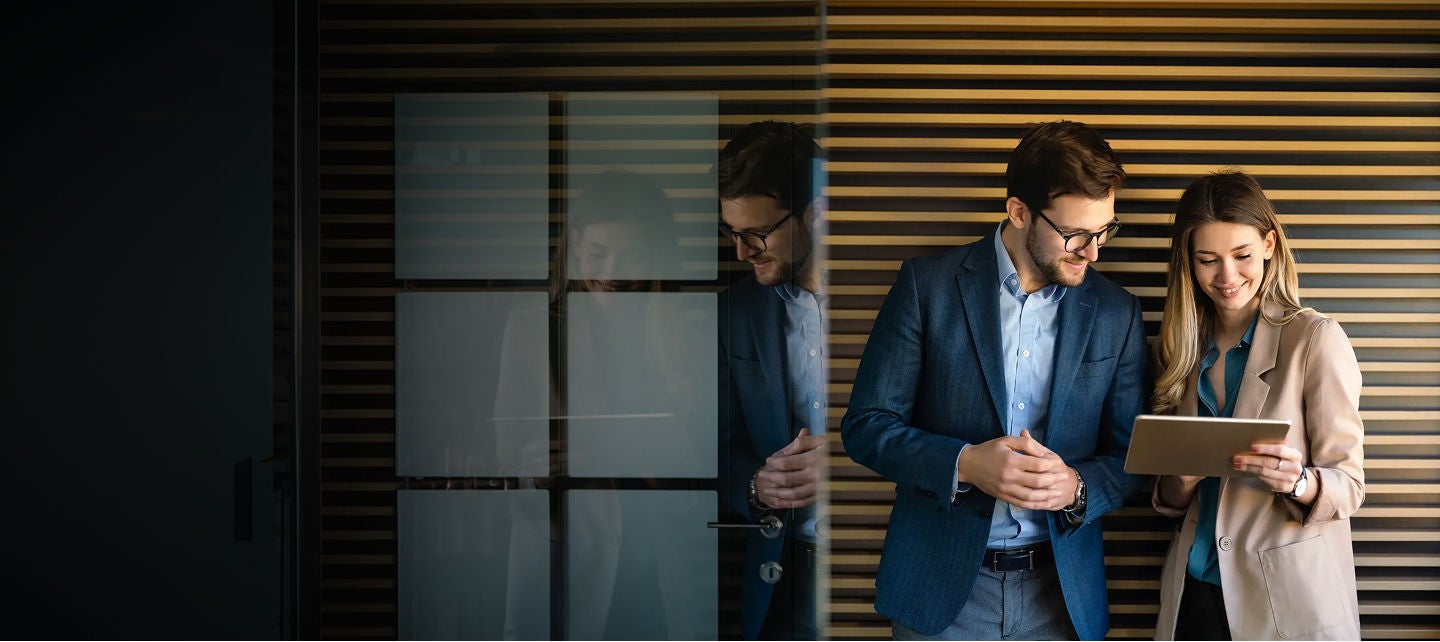 Two people working together alongside a window
