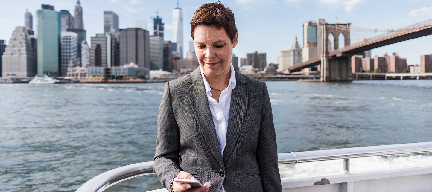 Woman browsing on her phone at a boat