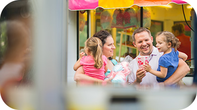 Family eating popcorn at an outdoor event.