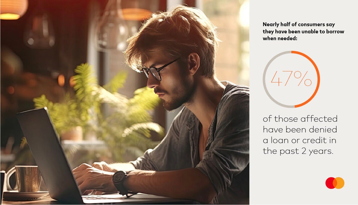 Man looking at a laptop with data points about consumer borrowing