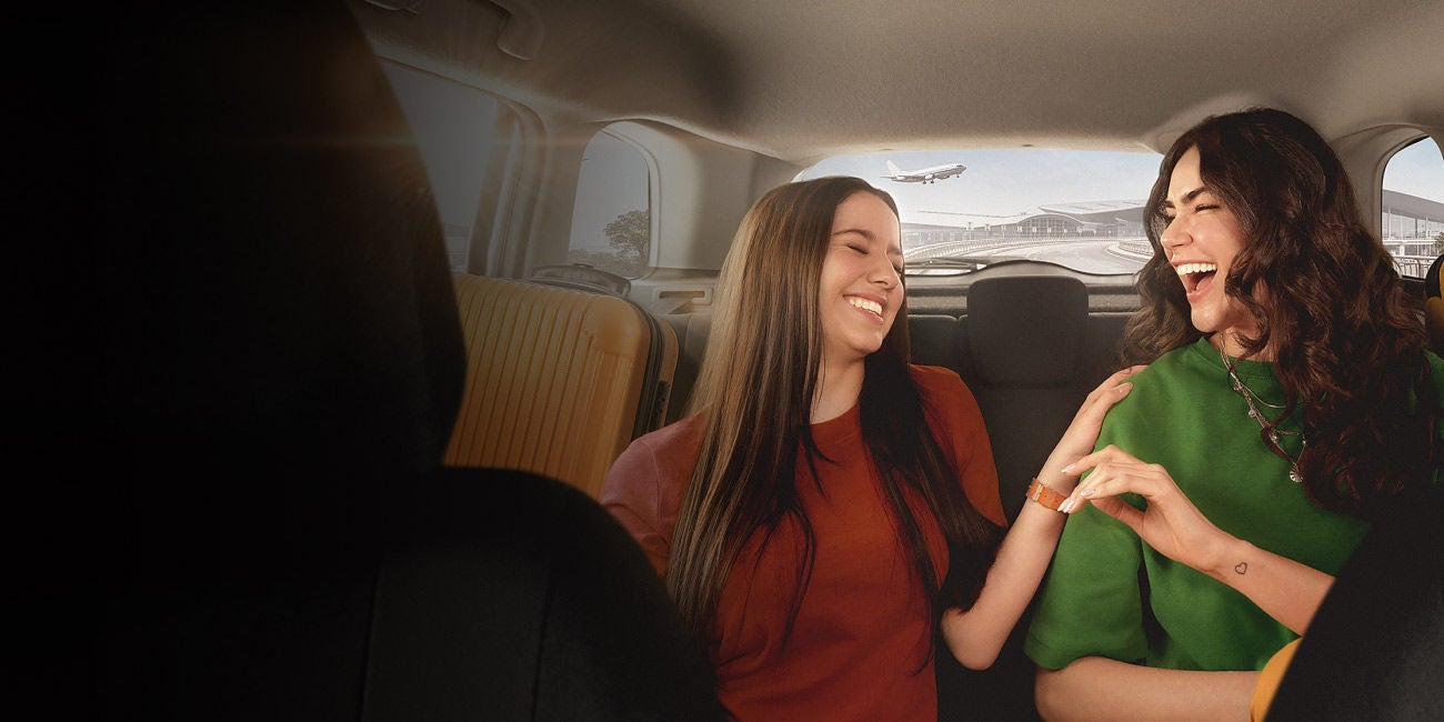 Two smiling people enjoying the benefits of being a Mastercard cardholder.