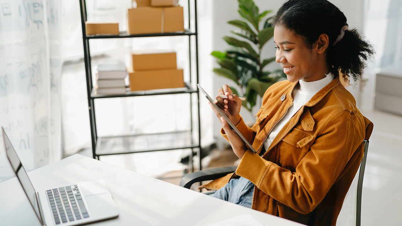 Woman on tablet in front of computer