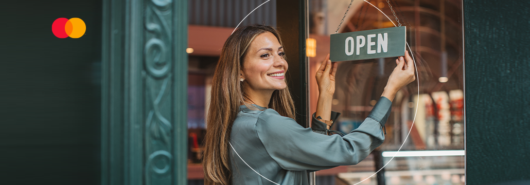Woman holding an open sign at a door