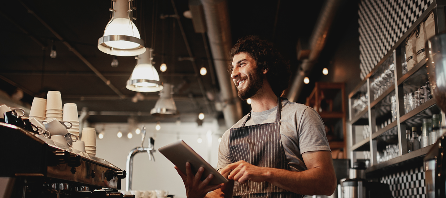 Barista looking at ipad behind desk