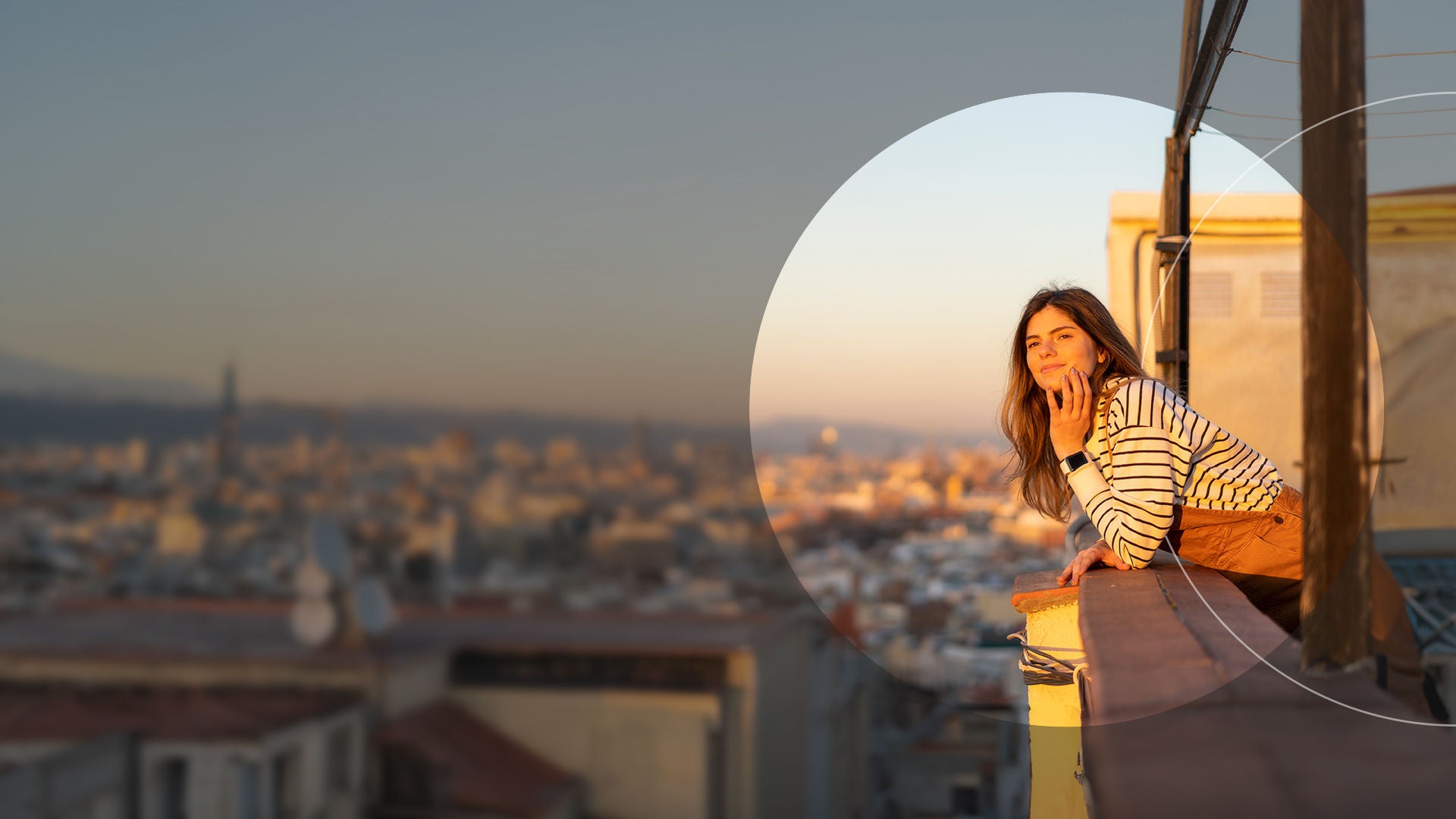 Girl on balcony looking out at city.