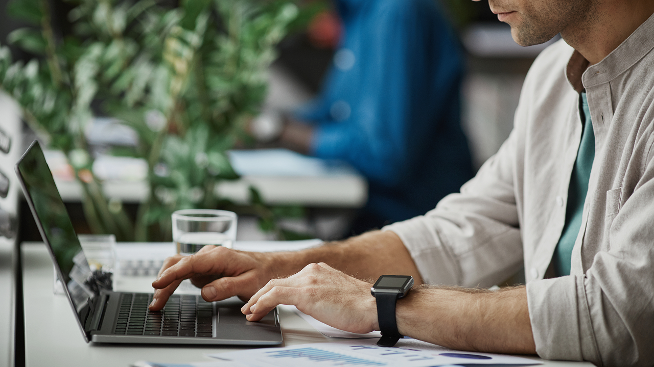 A man sitting at a desk using a laptop