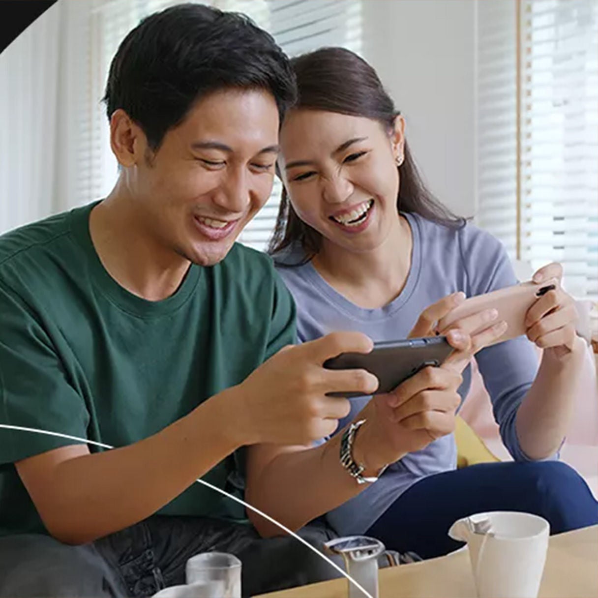 Couple playing mobile games together and laughing