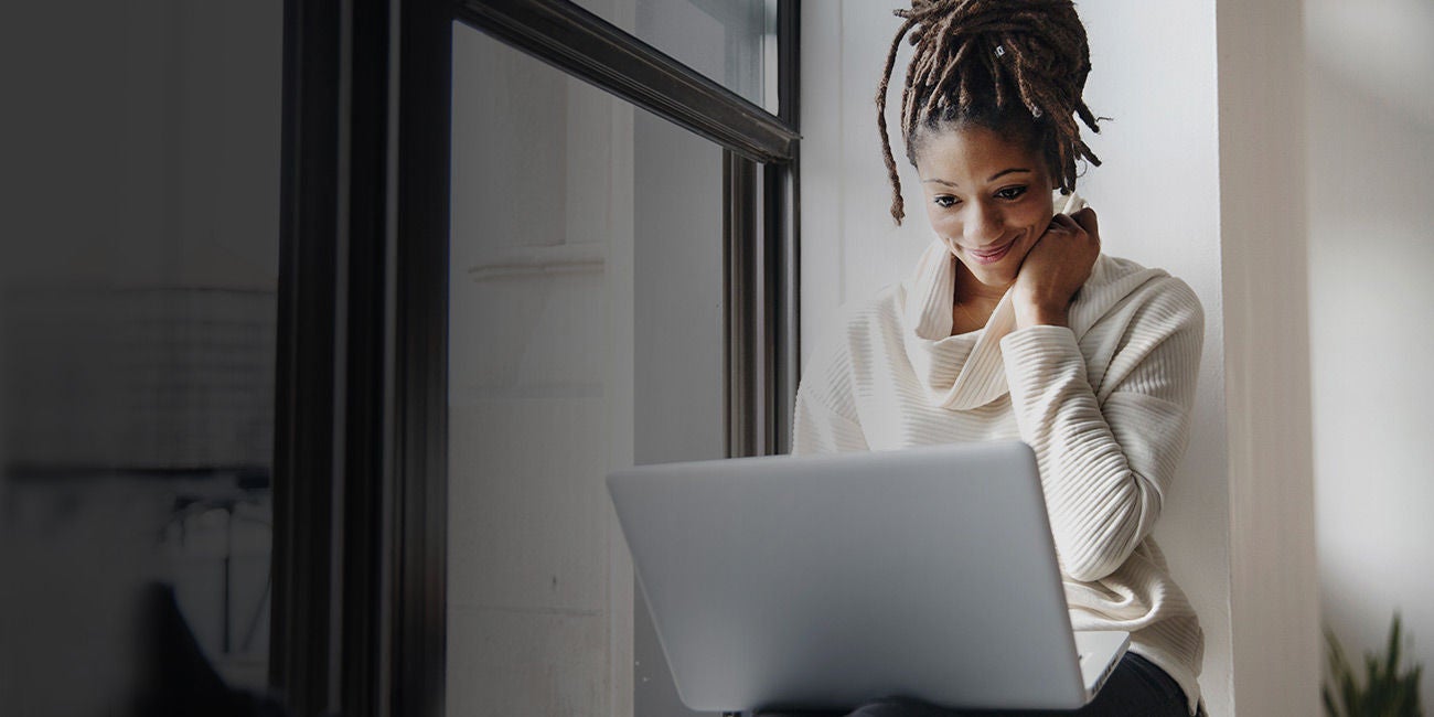 Two people smiling on a street.