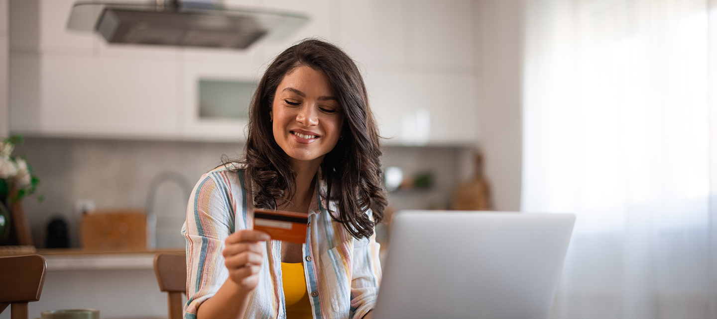 Woman making a purchase on her computer with card