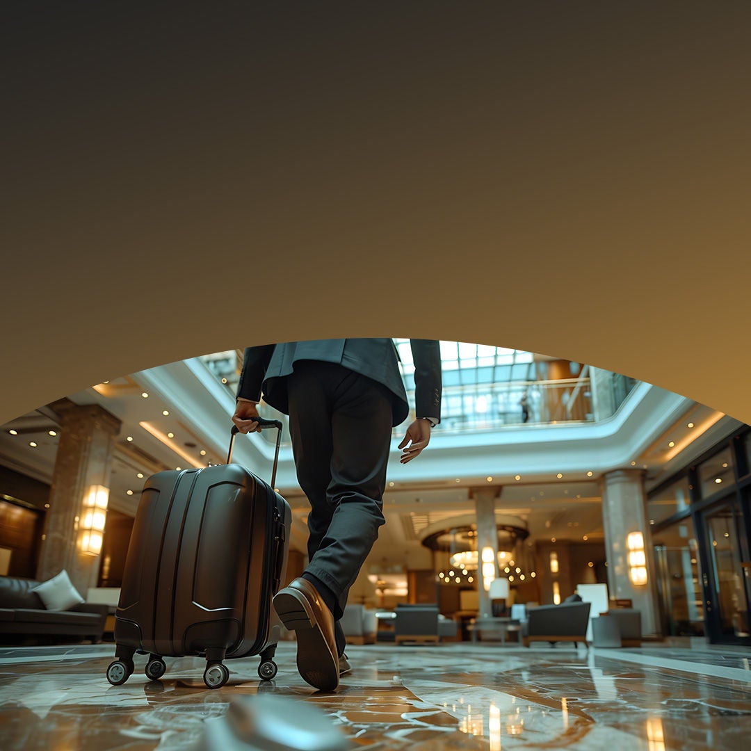 Businessman carrying his luggage in lobby of hotel.