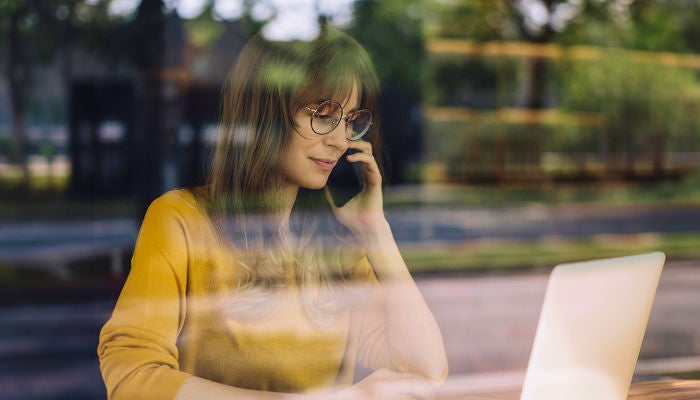 Woman on the phone behind a window