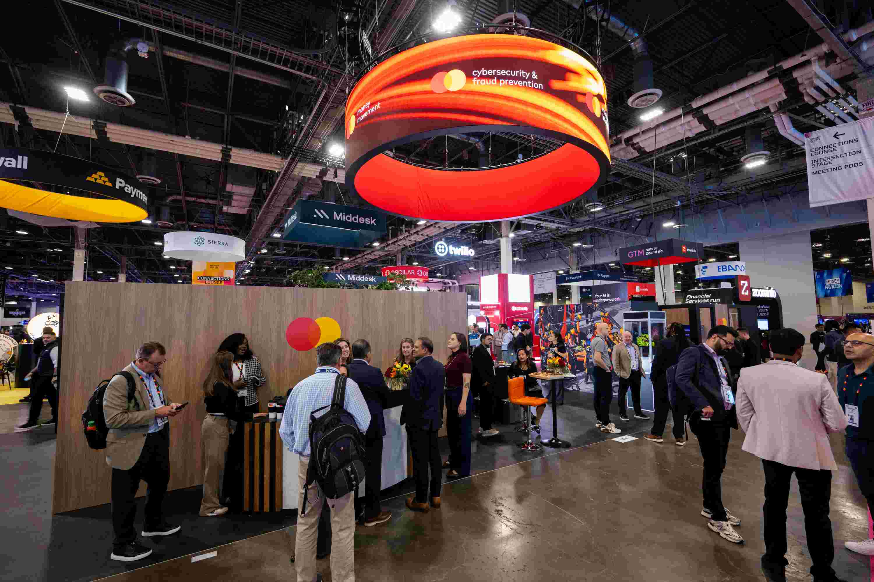 The Mastercard booth at Money 20/20 with people milling around. 