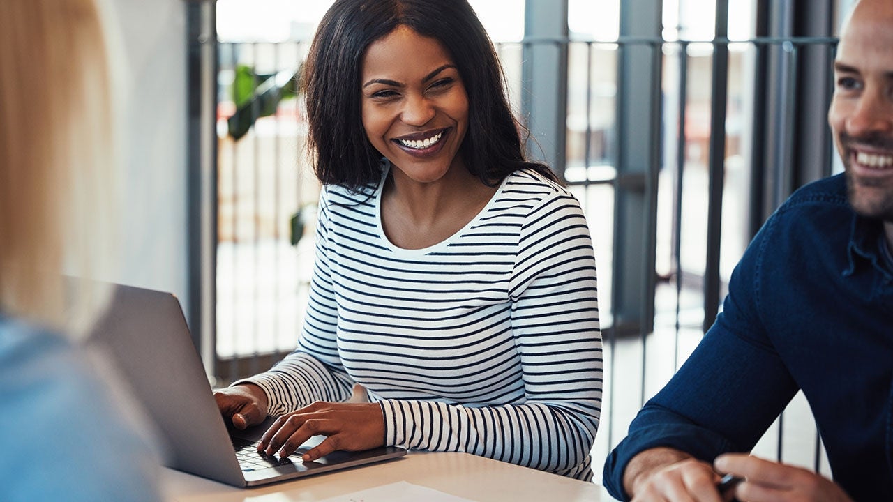 Smiling colleague with laptop.