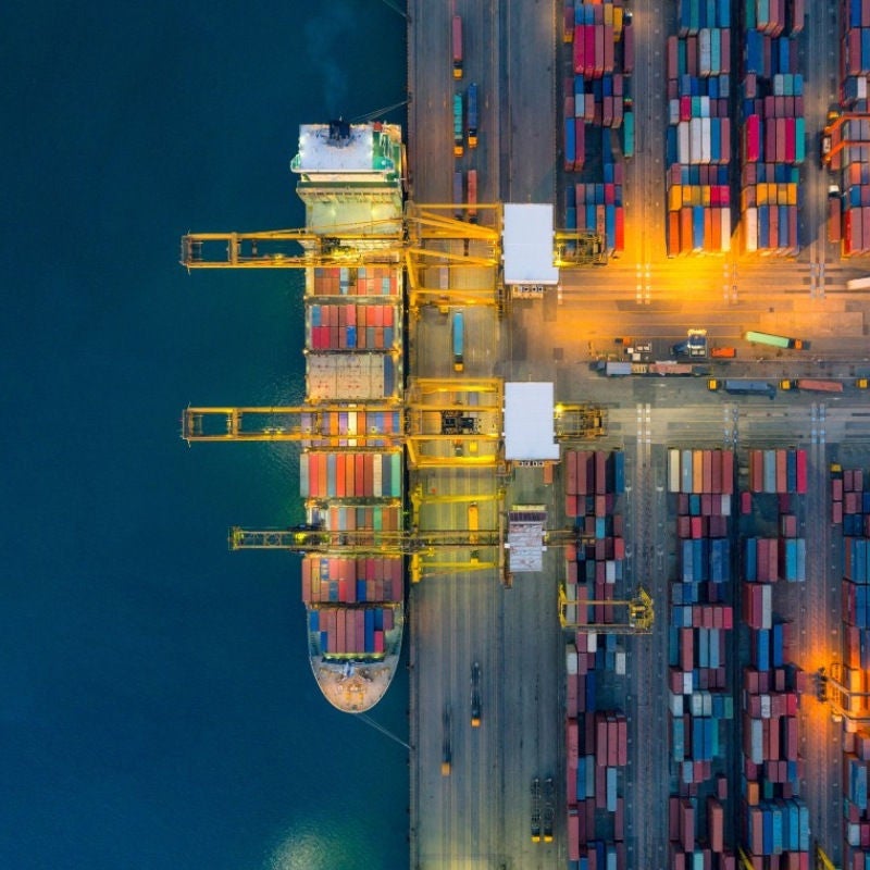A cargo ship at a dock unloading or loading containers. 