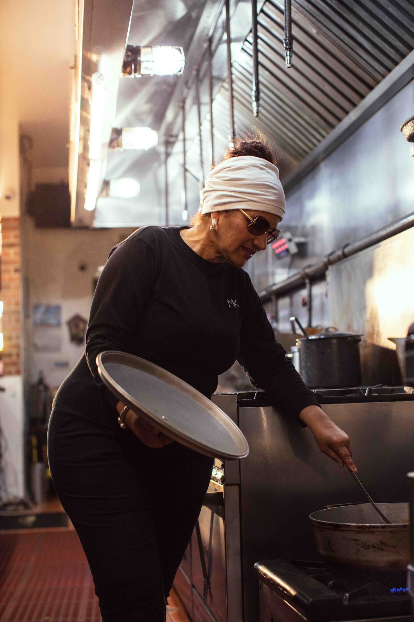 Morena Jorge stirs a pot in Morena's Kitchen and Bar. 
