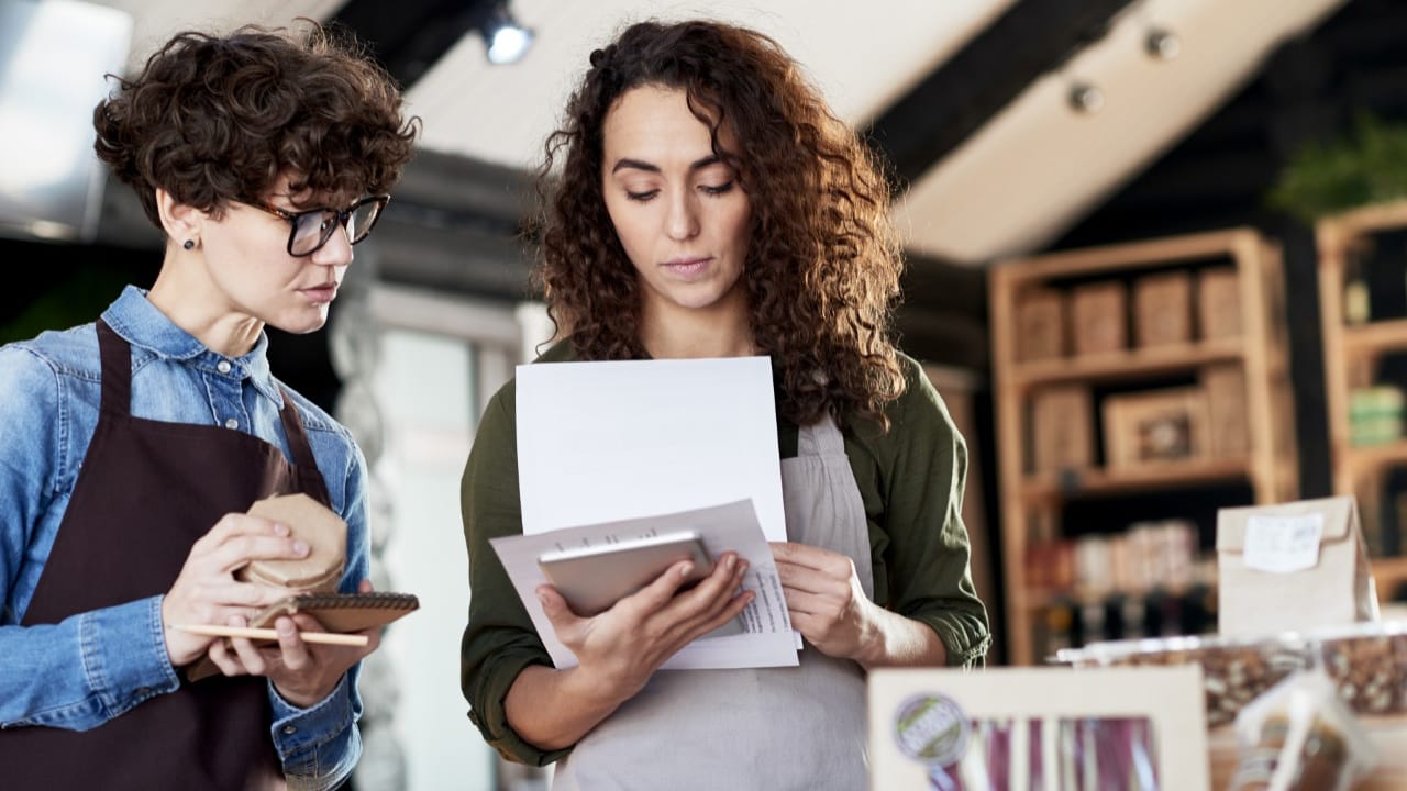 Small business owner checking documents with an employee.
