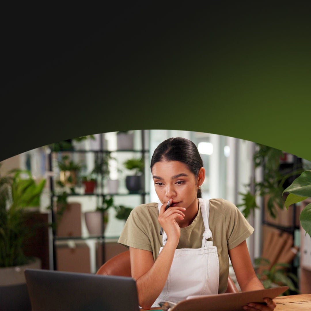 Female owner of a plant shop doing paperwork on her laptop