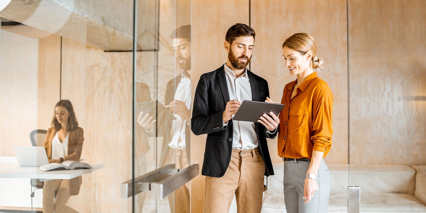 Two coworkers reviewing a tablet at the office