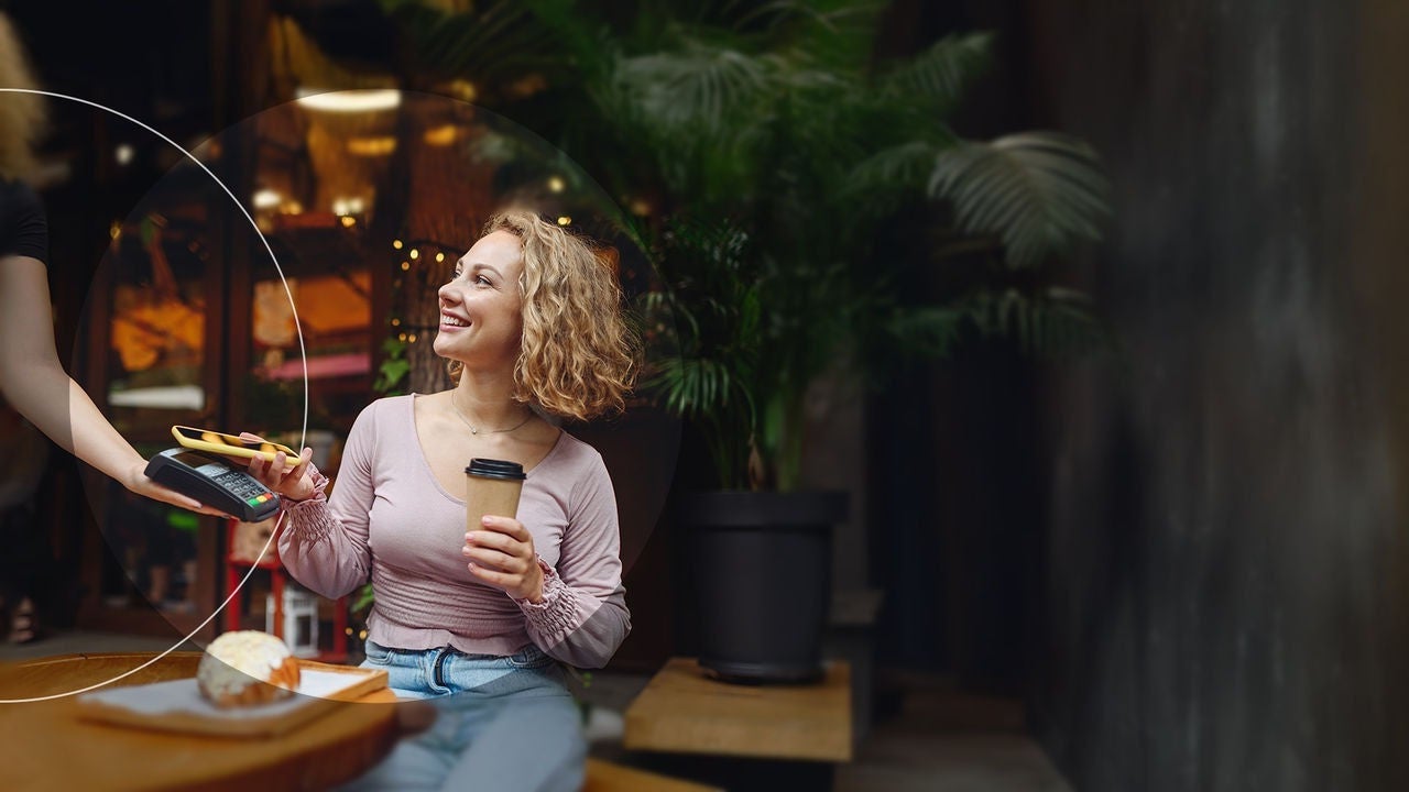 אישה מבצעת תשלום בבית קפה.
