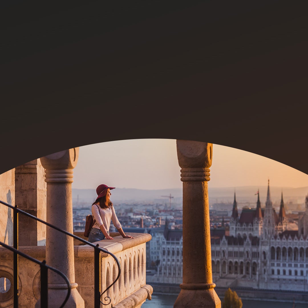 Person looking out over old city at dusk.