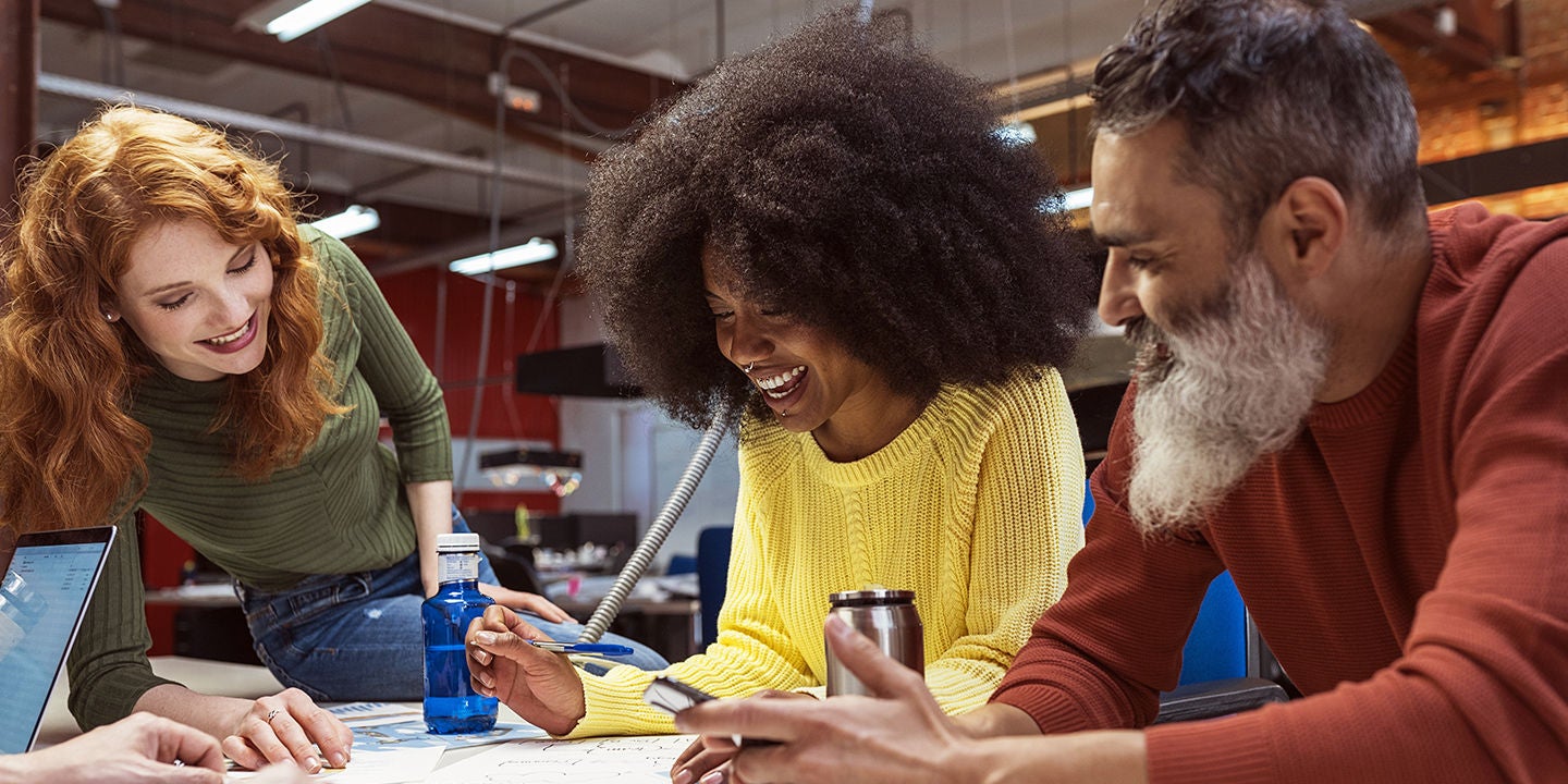 Playful young African American couple holding hands on sunny summer beach
