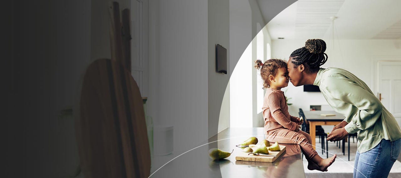 Mom touching heads with daughter in kitchen.