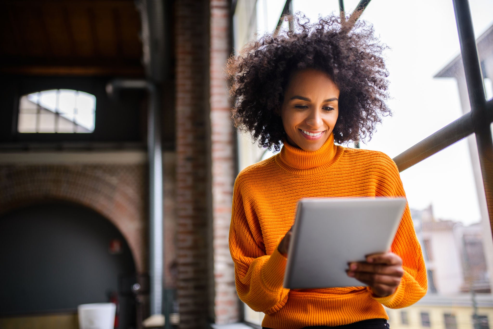 Smiling African American woman using digital tablet.