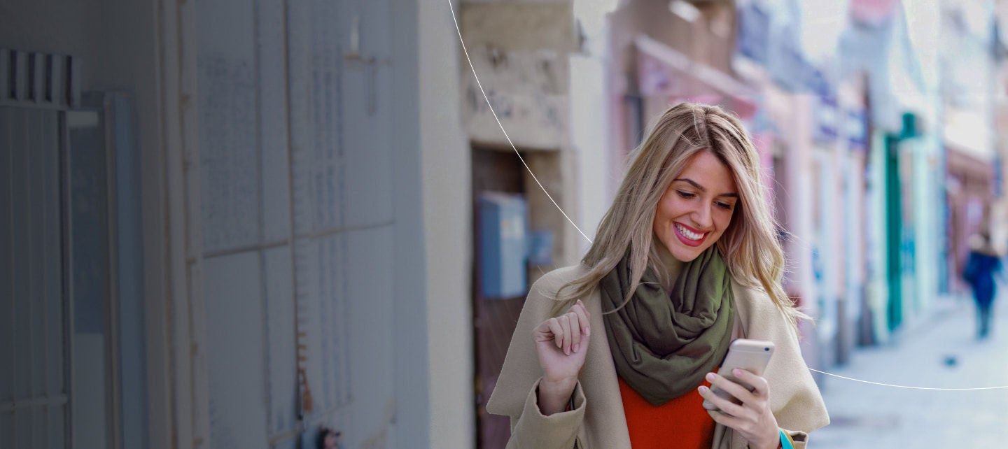 smiling blonde woman using smartphone