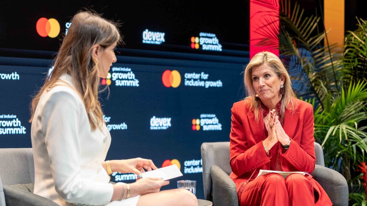 Haley Sacks and Queen Maxima are seated and speaking on stage at GIGS.