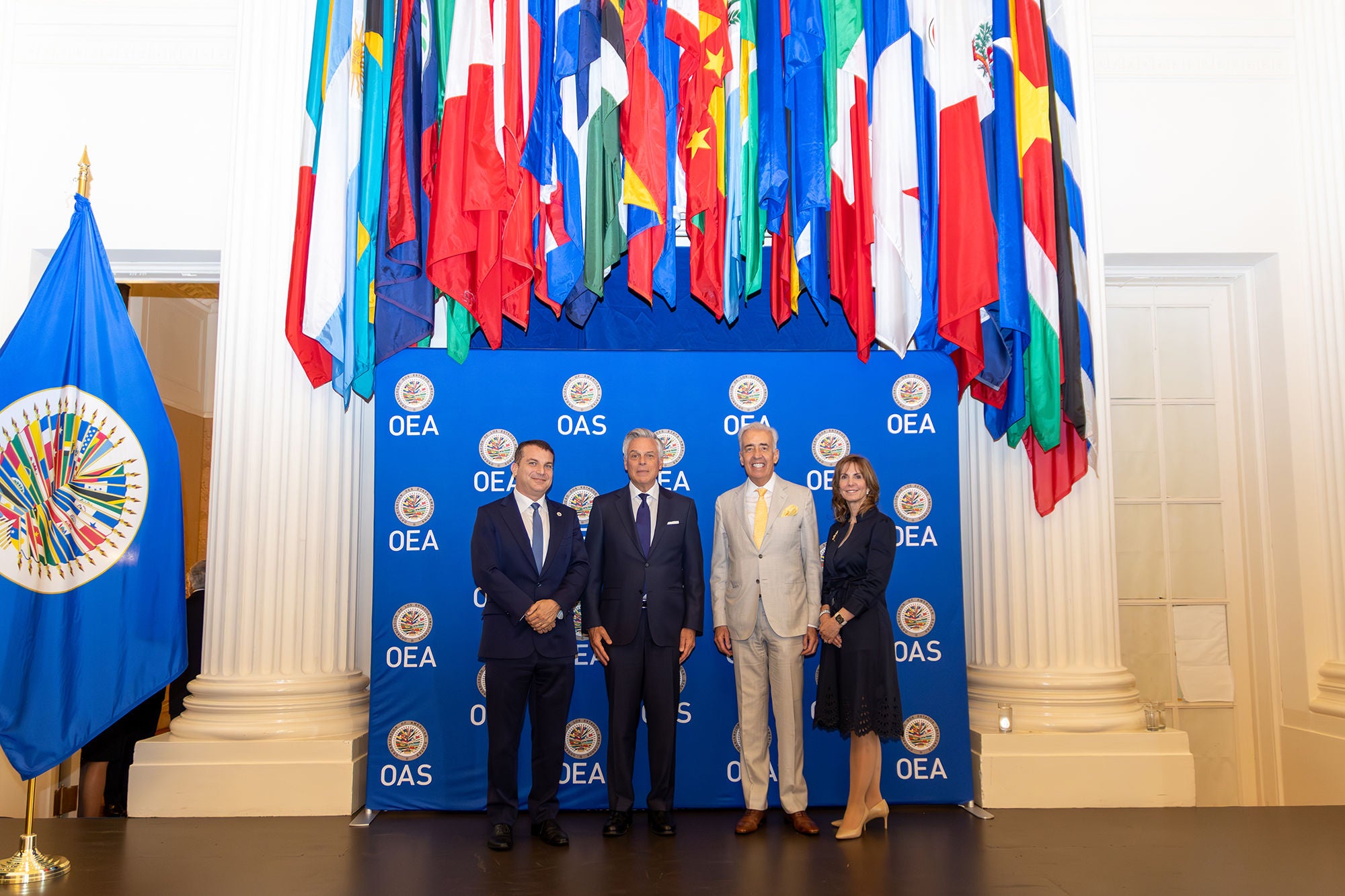 Four people standing under colorful flags